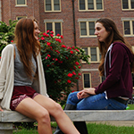 Photo of FSU students sitting on a bench outside of Landis Hall