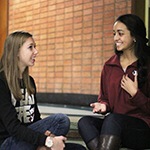 Photo of two FSU students sitting in hallway